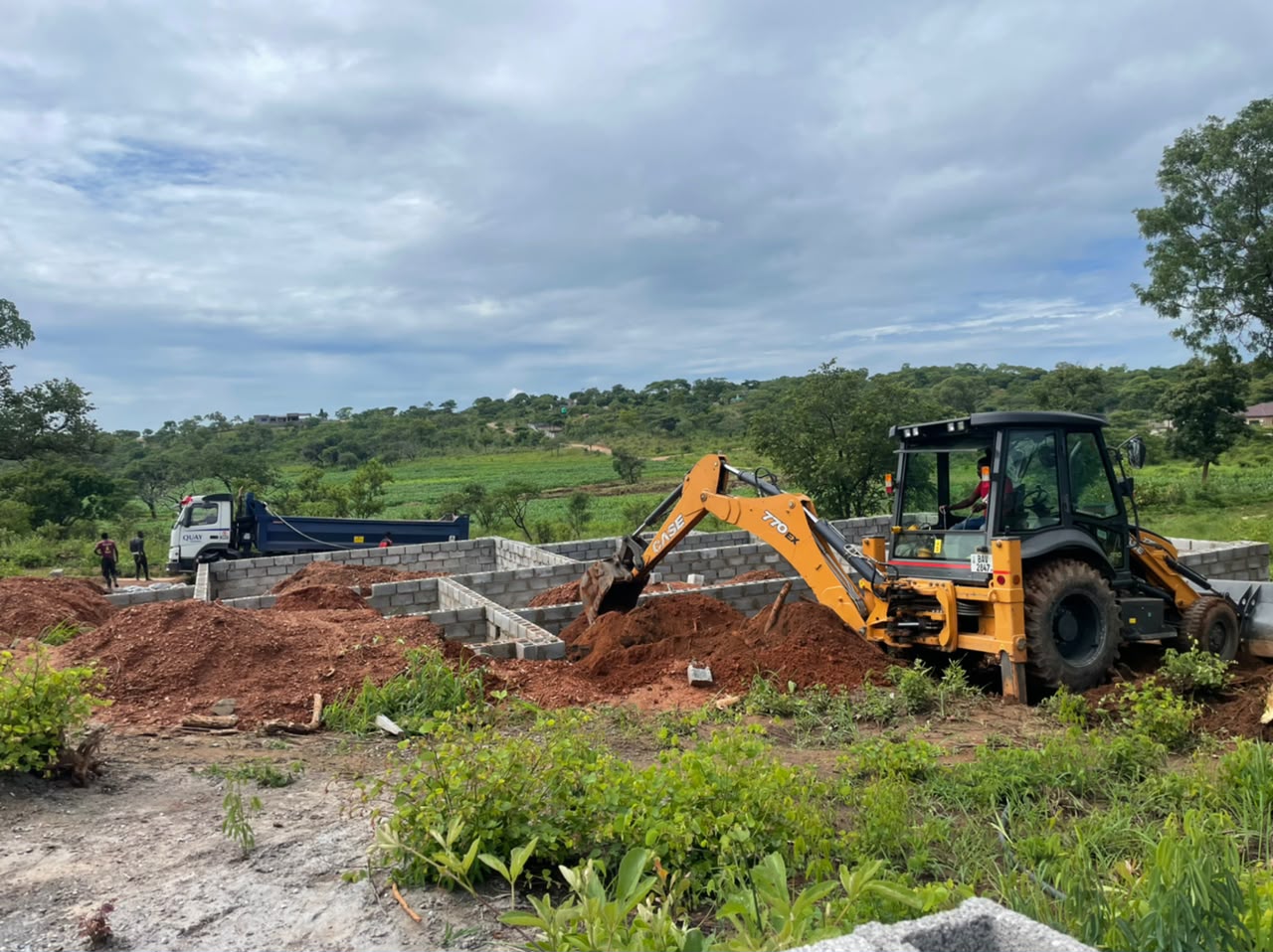 BMR backhoe digging next to foundation walls