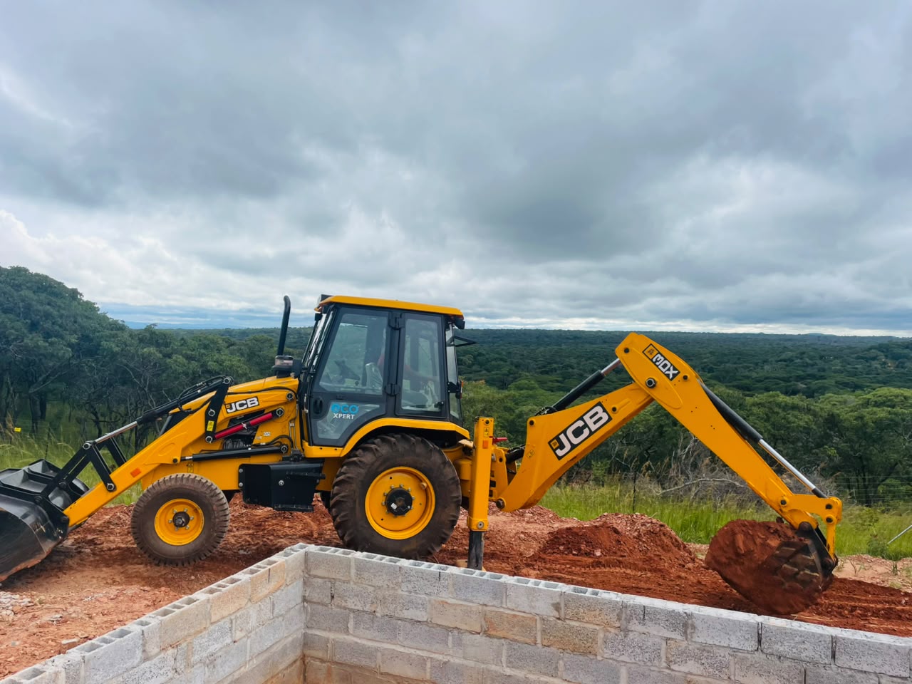 BMR backhoe loader beside block foundations on a building site