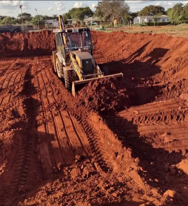 BMR backhoe cutting into red earth